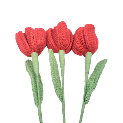 Three red crocheted tulips with green stems on a white background