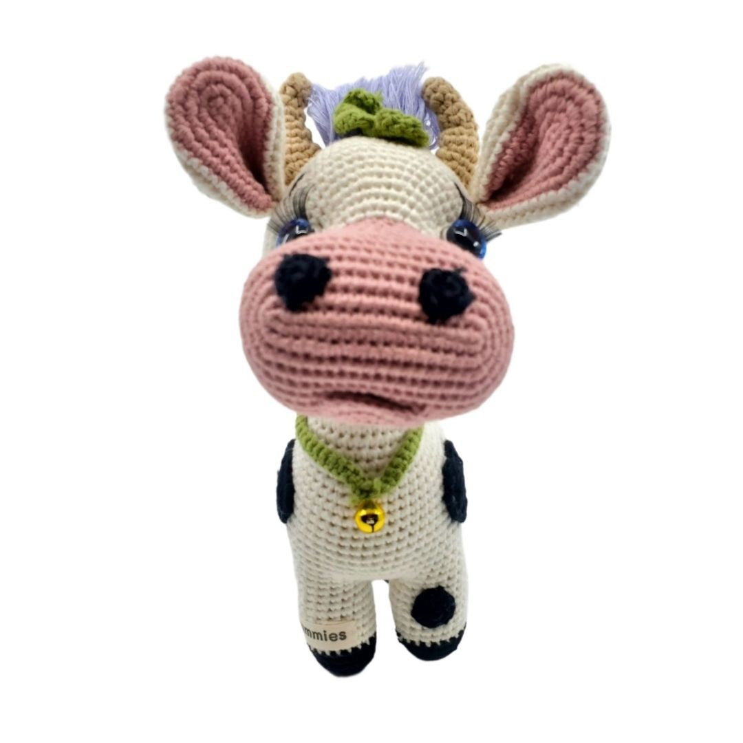 Crocheted cow plushie with a white background